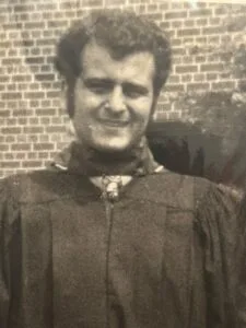 Photo of my father at his graduation many years ago, with dark, curly hair, clean-shaven and smiling.